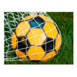 Ballon de football jaune et noir dans le filet cartes postales