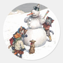 Chats adorables construisant un bonhomme de neige adhésif rond