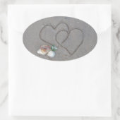 2 Harten in zand met schelpen Ovale Sticker (Tas)