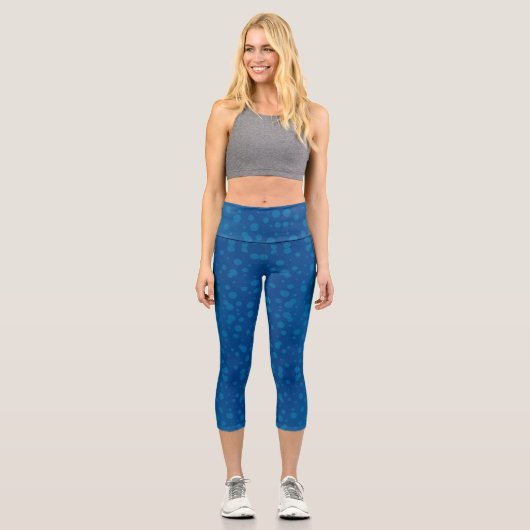 A woman's torso and legs in blue capri leggings (Recto)