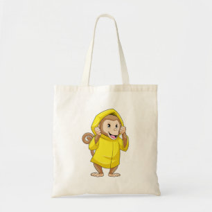 aap bij Raining met regenjas Tote Bag