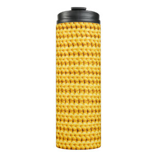 Achtergrond van geel gebreide wollen stof thermosbeker