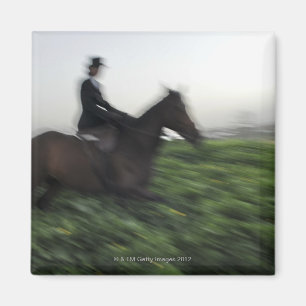 Aimant Équitation dans le champ vert. Femme à cheval