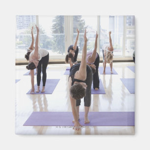 Aimant yoga de pratique de classe avec l'instructeur dans