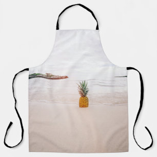 Ananas op zand nabij het strand schort