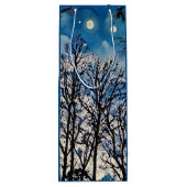 Arbres foncés contre un ciel bleu dans un sac cade (Dos)