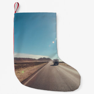 Auto op de zwarte asfaltweg kleine kerstsok
