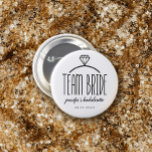 Bachelorette de l'équipe de ceinture de diamant<br><div class="desc">Bouton d'équipe en blanc avec texte noir charmant et illustration d'un anneau de fiançailles diamant. Personnalisez avec le nom de la mariée (ou le nom du porteur) et la date de l'événement.</div>