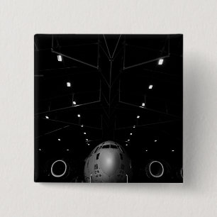 Badge Carré 5 Cm Un C-17 Globemaster III est assis dans un hangar