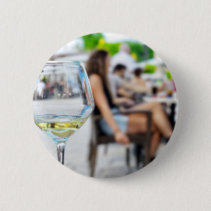 Badge Rond 5 Cm Verre vide du vin et silhouettes floues