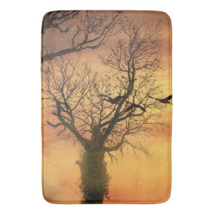 Badmat gedraaide herfstboom bij zonsondergang