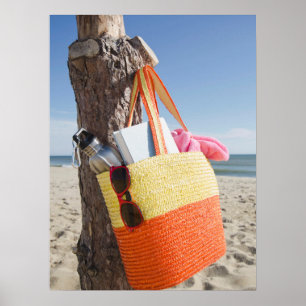 Bag die op boomstam hangt bij zandstrand poster