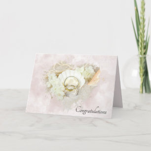 Bagues de mariage dans une carte de cœur de coquil