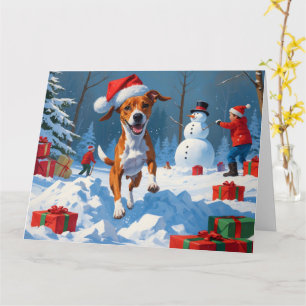 Basenji-hond speelt in de sneeuw winterscène kaart