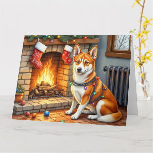 Basenji zittend bij de open haard met kerstverlich kaart