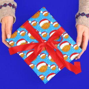 Basketbal die Santa's hoed en sneeuwvlokken draagt Cadeaupapier
