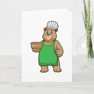 Beer als kok met kookschort en houten kom kaart
