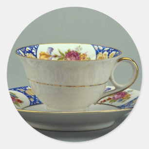 Beker en saucer met kleurrijke design erop. ronde sticker