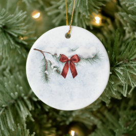 besneeuwde dennentak met een feestelijke rode stri keramisch ornament