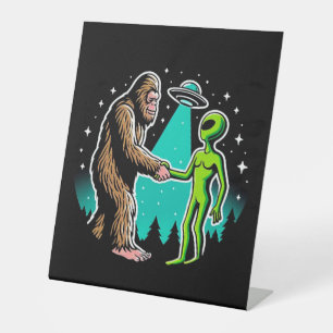 Bigfoot ontmoet buitenaards wezen reclamebord met voetstuk