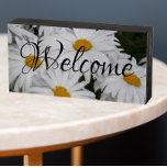 Blancs Fleur Bienvenue<br><div class="desc">Bienvenue dans votre maison avec ce panneau décoratif en bois conçu pour être suspendu ou debout et qui présente une photo de jolies marguerites blanches et le mot "Bienvenue" en texte blanc stylisé. Un joli design floral ! Sélectionnez la couleur du panneau de votre boîte en bois.</div>