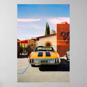 Blauwe auto geparkeerd naast bruin betongebouw in poster