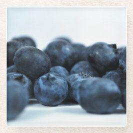 Blauwe bessen op witte tafel glazen onderzetter