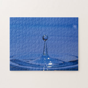 Blauwe druppel water in beweging op een puzzel