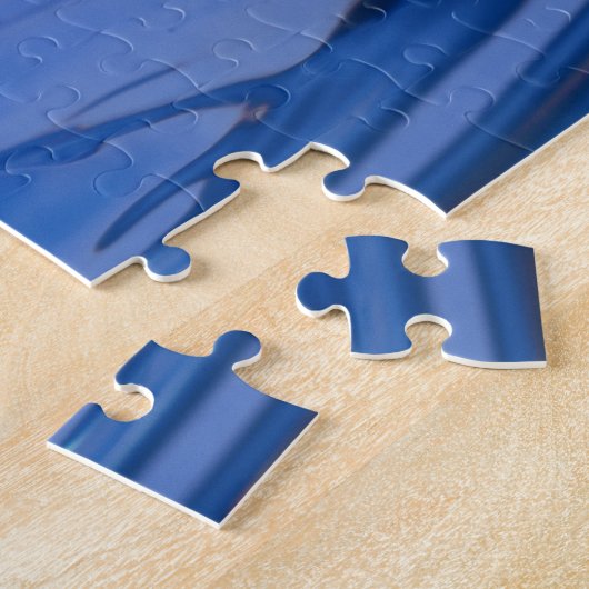 Blauwe druppel water in beweging op een puzzel legpuzzel (Zijkant)