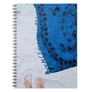 Blauwe en zwarte florale sjaal op wit zand notitieboek