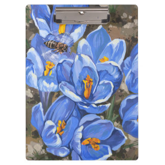 Blauwe krokussen en een bij klembord