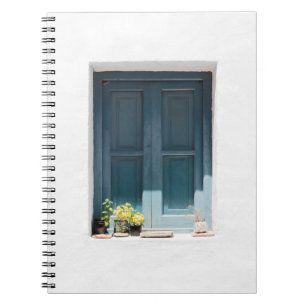 BLAUWE WOODEN DEUR OP WITTE CONCRETE WAL NOTITIEBOEK