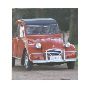 Bloc-note Une vieille voiture Citroen 2CV rouge avec une fem