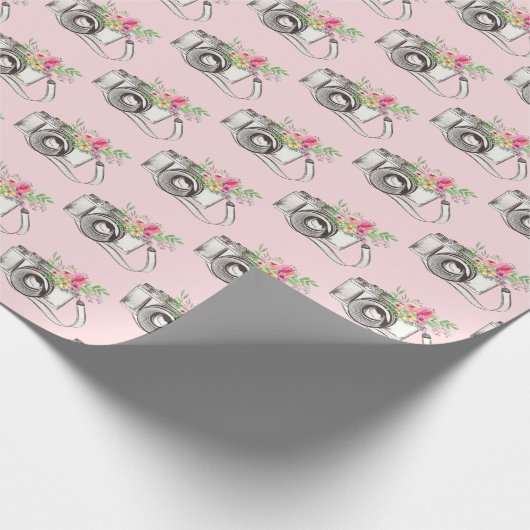 Bloemen en camera op roze cadeaupapier (Hoek)