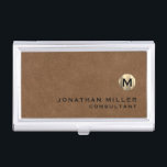 Boîtier Pour Cartes De Visite Luxe Brown Suede or Monogramme<br><div class="desc">Design moderne simple avec médaillon de monogramme en or métallique brossé de luxe avec nom et titre personnalisés ou texte personnalisé ci-dessous en typographie de bloc classique sur un arrière - plan texturé en cuir marron. Personnalisez pour votre usage personnalisé.</div>