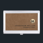 Boîtier Pour Cartes De Visite Luxe Brown Suede or Monogramme<br><div class="desc">Design moderne simple avec médaillon de monogramme en or métallique brossé de luxe avec nom et titre personnalisés ou texte personnalisé ci-dessous en typographie de bloc classique sur un arrière - plan texturé en cuir marron. Personnalisez pour votre usage personnalisé.</div>