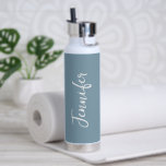 Bouteille D'eau Élégante Dusty Bleu blanc Script femmes<br><div class="desc">Restez hydratés pendant votre entraînement de gym avec cette bouteille d'eau élégante Dusty Blue Script Women's. Moderne et tendance, il est décoré d'un arrière - plan bleu branché autour de la bouteille. Le nom est en écriture manuscrite blanche en lettres verticales sur le devant central. Idée cadeau parfaite pour elle...</div>