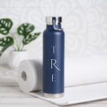 Bouteille D'eau Monogramme chic sur bleu<br><div class="desc">Le chic monogramme vertical blanc sur le bleu présente une plus grande initiale décorative au centre. Remplacez les 3 initiales par les vôtres dans la barre latérale. Autres couleurs et styles de bouteilles d'eau disponibles dans la barre latérale. Copyright © Claire E. Skinner. Tous droits réservés.</div>