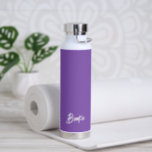 Bouteille D'eau Nom simple élégant Purple Moderne<br><div class="desc">Bouteille d'eau moderne avec un design simple et minimaliste avec votre nom dans un script élégant sur un arrière - plan violet de raisin. Un design mignon parfait pour une petite fille.</div>