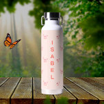 Bouteille D'eau Papillons pêche nom or rose<br><div class="desc">Arrière - plan de couleur chair décoré de papillons roses et roses en or. Personnalisez et ajoutez votre nom. Posez des lettres colorées.</div>