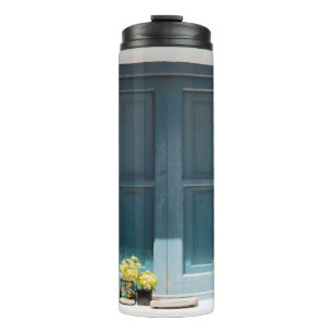 BOUTEILLES ISOTHERMES PORTE EN BOIS BLEU SUR MUR BLANC EN BÉTON