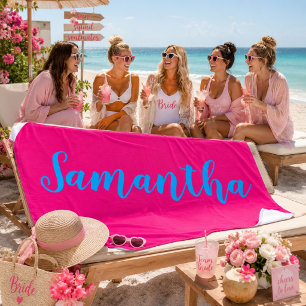 Bruidstrip aan het strand in hete roze strandlaken