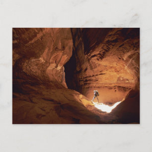 Canyoneer verlicht in de diepten van een smalle kl briefkaart