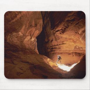 Canyoneer verlicht in de diepten van een smalle kl muismat