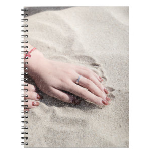 Carnet Femme allongée sur le sable blanc
