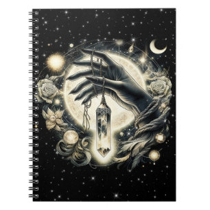 Carnet Main tenant un cristal sous la lumière de la lune