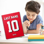 Carnet Nom rouge personnalisé Numéro de maillot sport<br><div class="desc">Le nom,  le nombre et l'ombre portée sont personnalisables afin que vous puissiez rendre un carnet sportif à la fois utile et unique et correspondant aux couleurs de votre équipe sportive préférée ou de la décoration de la chambre. Arrière - plan rouge.</div>