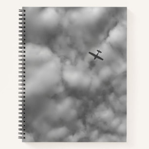 Carnet Petit avion volant dans un ciel nuageux Photo