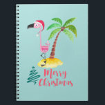 Carnet Pink Flamingo In A Santa Hat By A Palm Tree Xmas<br><div class="desc">A notebook with a cute illustration of a pink flamingo in a red santa hat. Standing beside a green palm tree on a mound of yellow sand. A fancy swirly christmas tree design is placed beside the text Merry Christmas. Written in the color pink in a fancy handwritten font. Pastel...</div>