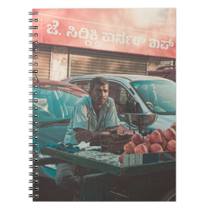 CARNET POMMES DE VENTE D'HOMME PRÈS DES VOITURES PARKÉES